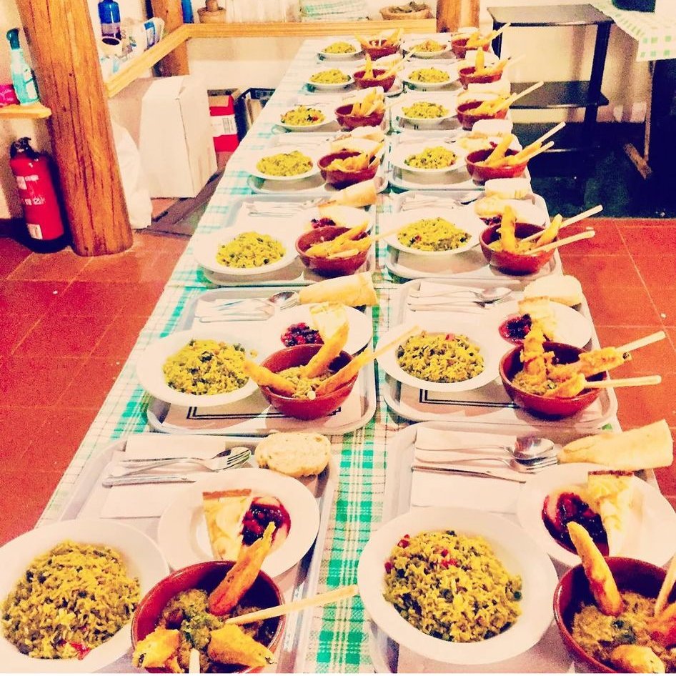 Mesa larga con platos del almuerzo del retiro en el cortijo