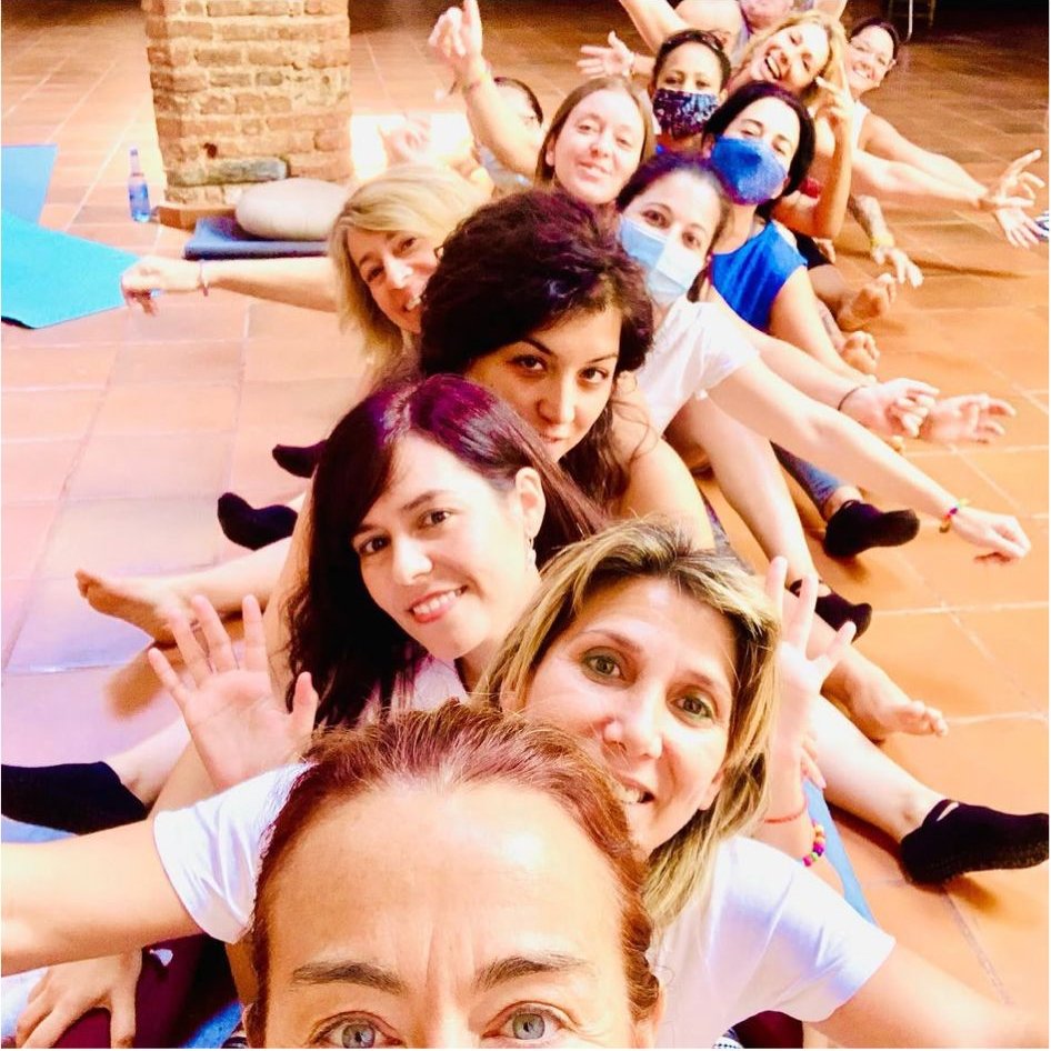 Grupo de mujeres en sesión de yoga en el cortijo, riendo